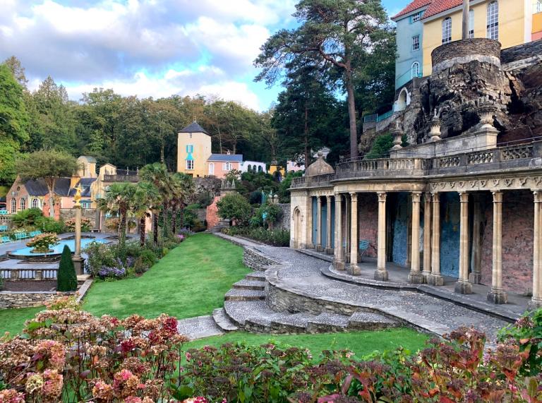 Portmeirion village with buidlings of italianate architecture and gardens beyond the trees.