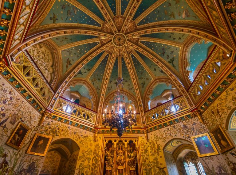 looking up at a ornately decorated domed ceiling inside Castell Coch