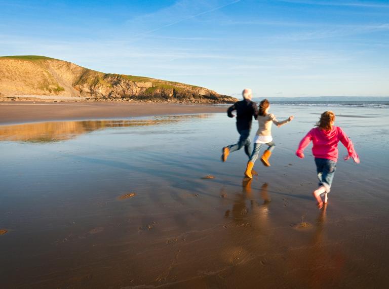 Image of a family running on the beach.