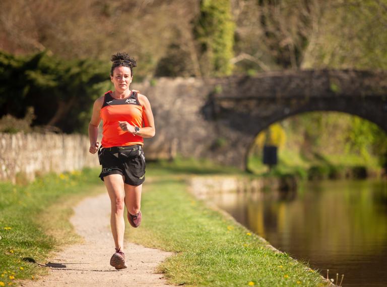 Woman running on a canal tow path.