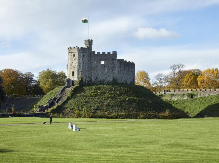 The grass covered ground inside Cardiff Castle with the Castle Keep in the background