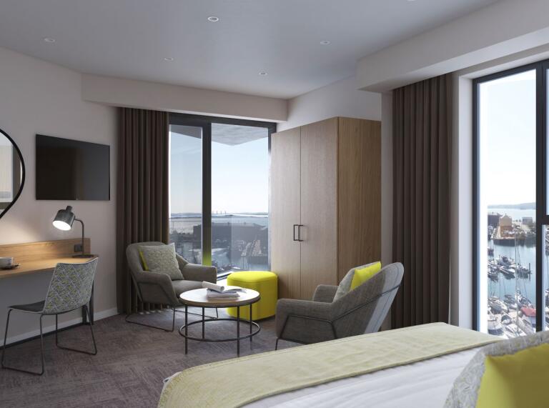 Ein Hotelzimmer mit bequemen Sesseln und großen Fenstern mit Blick auf den Hafen.