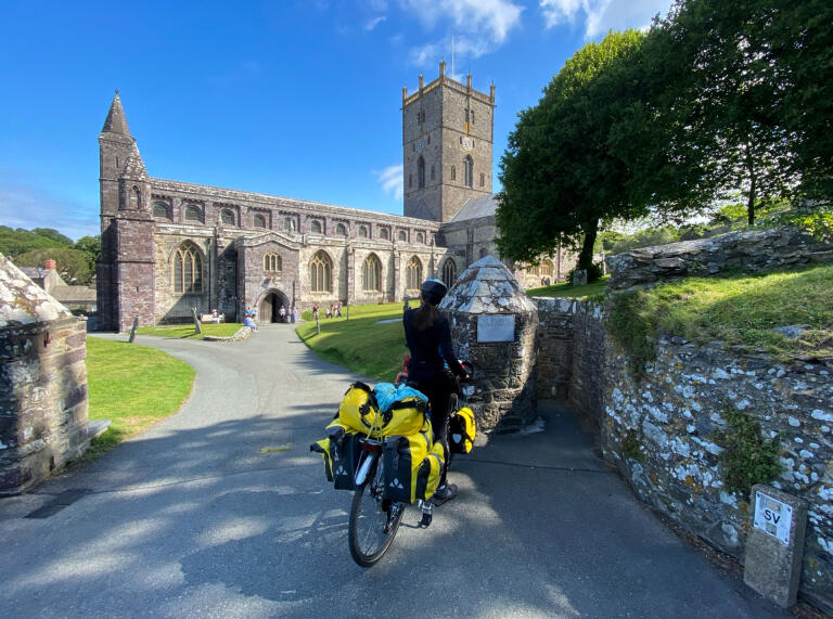 A cyclist stood outside a cathedral