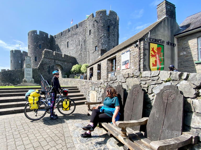 Menschen und Fahrräder außerhalb von Pembroke Castle.