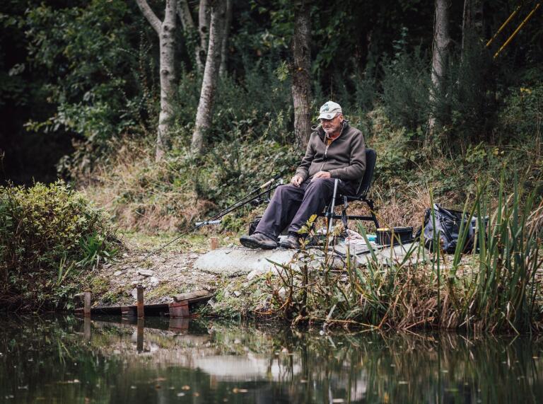 man fishing by lake.