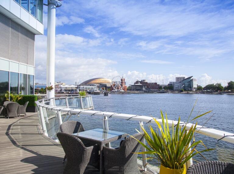 hotel terrace with seating and view of Cardiff Bay.