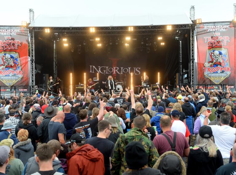 a crowd of people facing a festival stage.