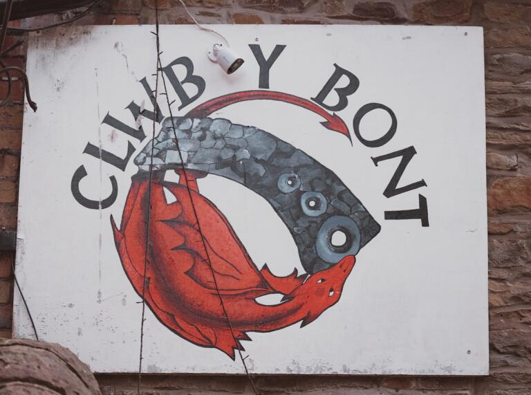 A retro Clwb y Bont sign. The logo has the red dragon and Pontypridd's iconic bridge in a circle. 
