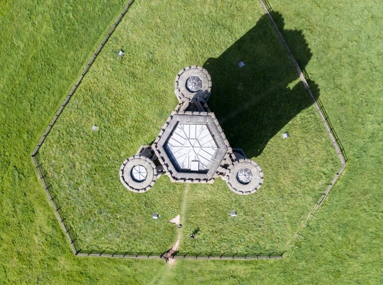 An aerial view of a hexagonal tower with three round towers off the sides.