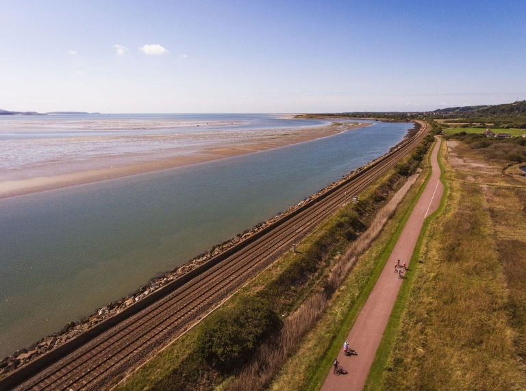 A railway line and cycle / footpath alongside an estuary.
