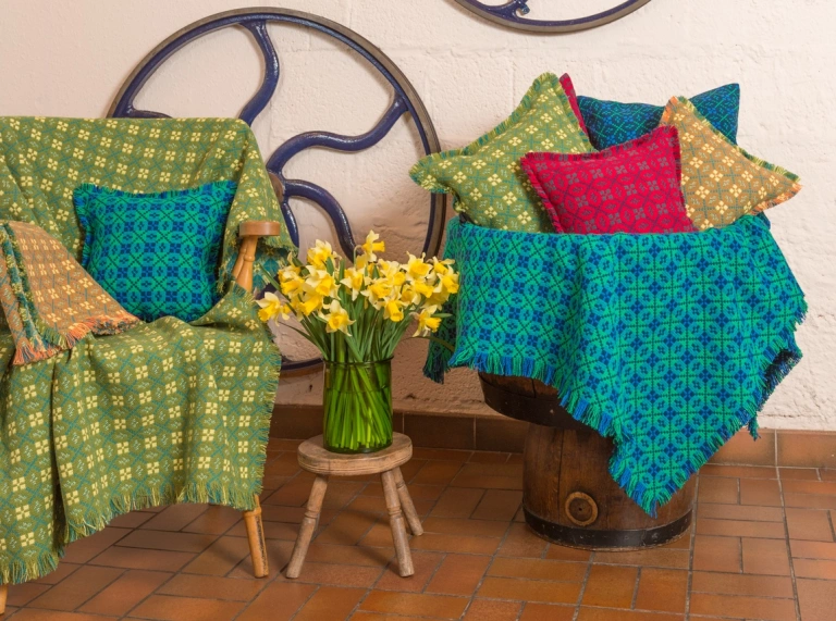 Colourful Welsh tapestries displayed on a chair and barrel 