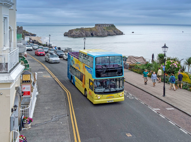 open top bus in Tenby town centre on coastal road.