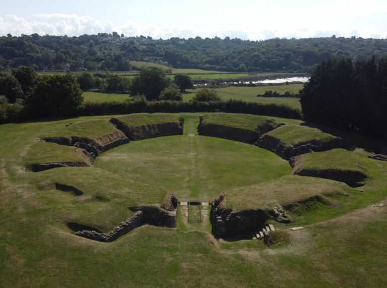 Ruins of a Roman amphitheatre - the grass-covered outlines of the walls are visible.