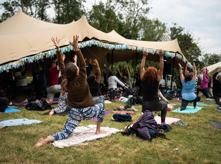 People practicing yoga at a festival.