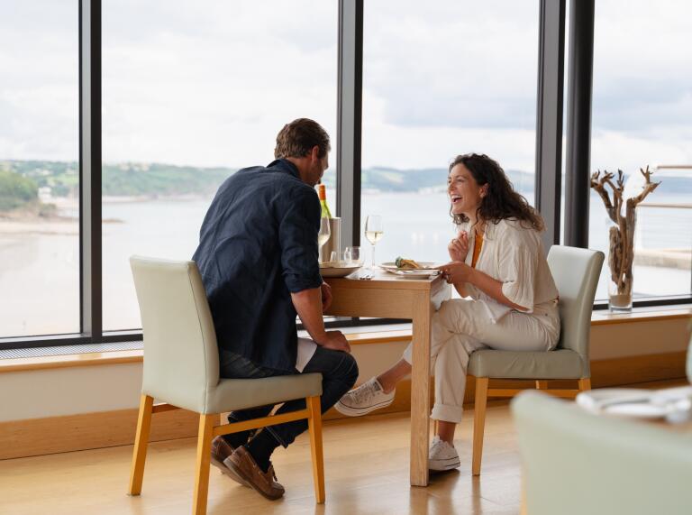 couple dining with view of coast.