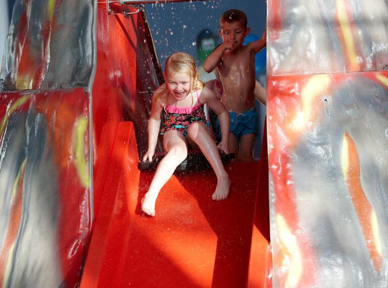 girl and boy on water slide.