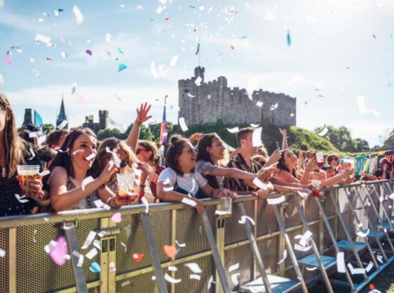 crowd at event at Cardiff Castle, with pieces of paper floating in air.
