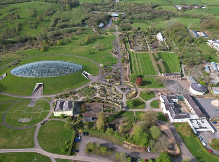 Aerial view of a garden, with a huge dome, structured gardens and paths.