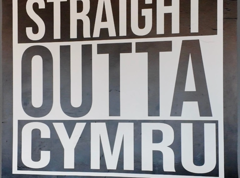 sign 'Straight Outta Cynru' on grey wall.
