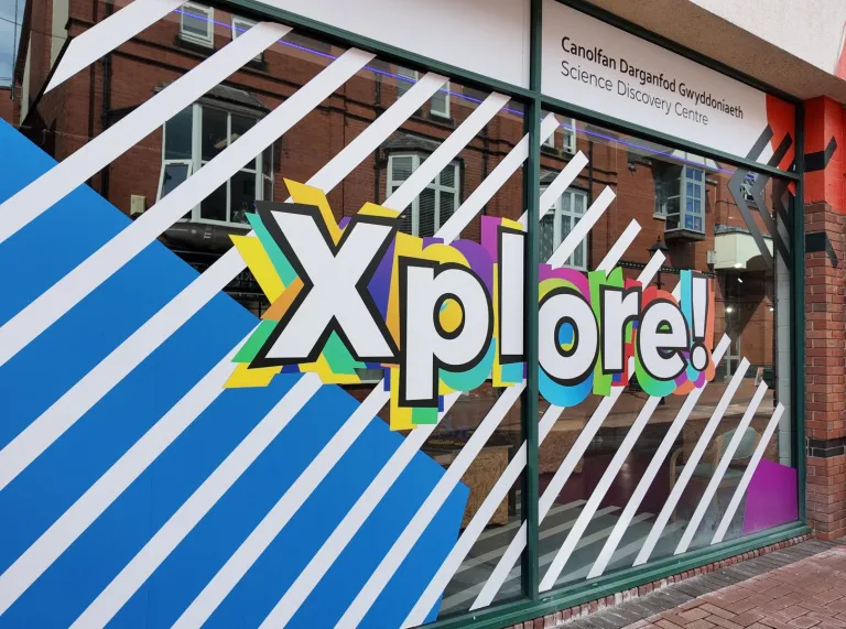 Exterior of building with the colourful words Xplore! on windows.