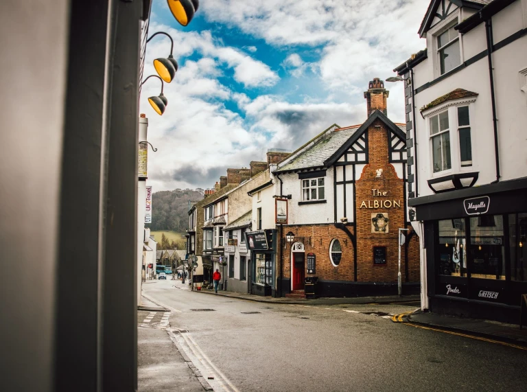 Eine Straße mit Häusern zu beiden Seiten und einem Hügel im Hintergrund.