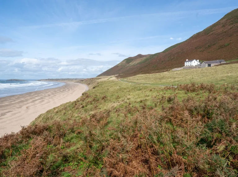 Sweeping sandy beach with a rectory positioned looking at the sea front