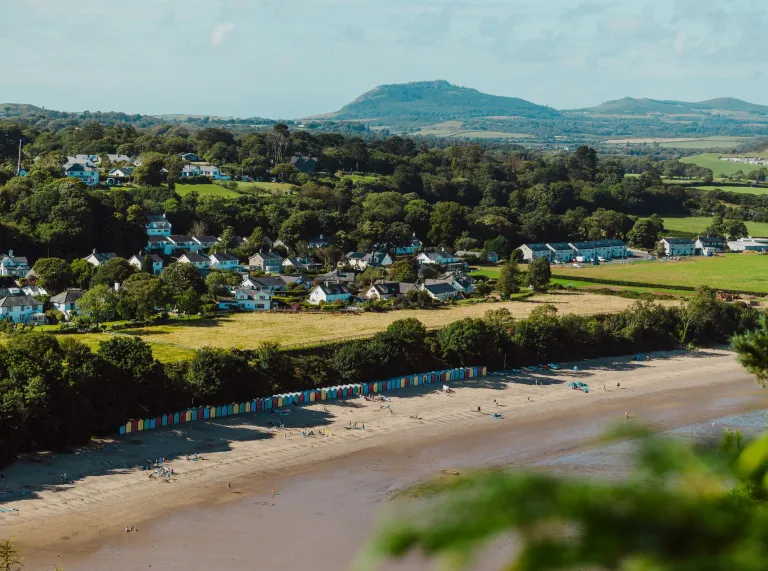 A long sandy beach on the edge of a village. 