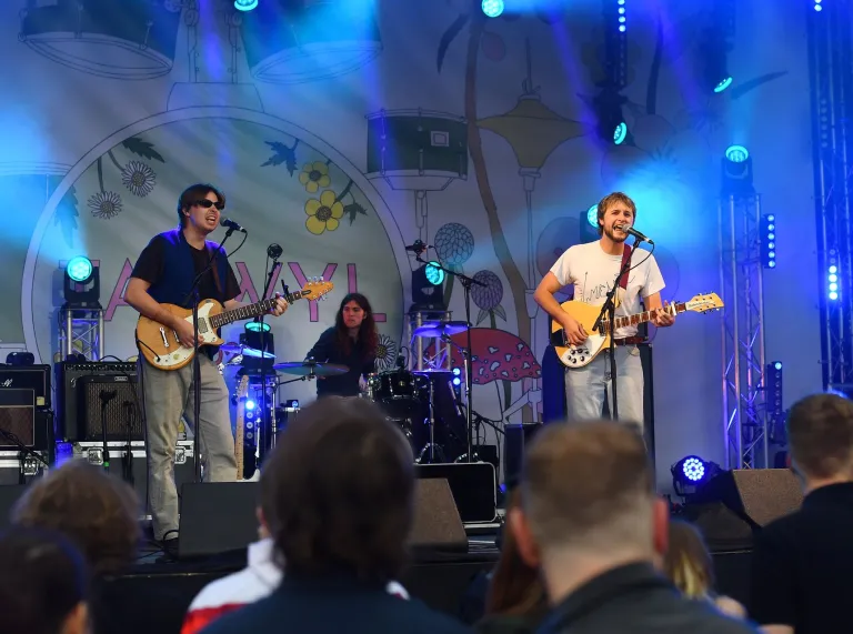 band on stage with people watching.