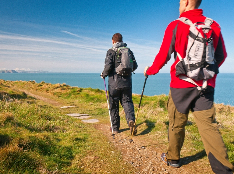 two walkers on coast path.