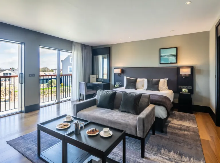 A hotel bedroom with a plush sofa and large sliding patio doors.