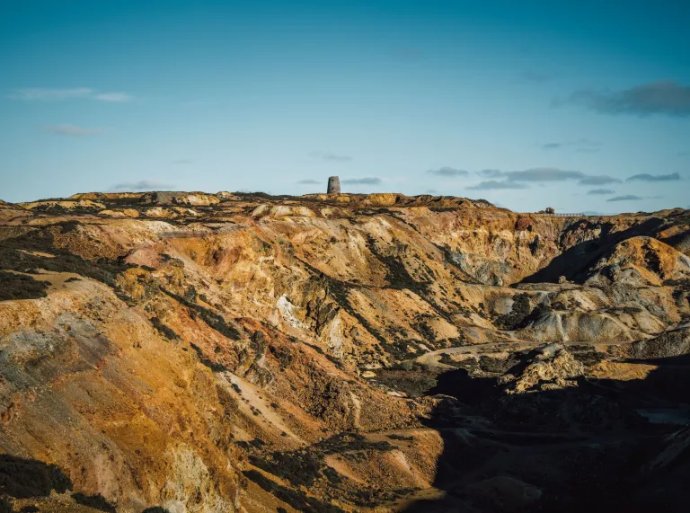 An open cast copper mine with rocks of all hues - red, orange, pinks and browns.