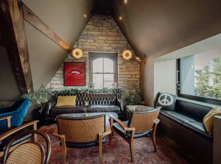Lounge area at Hickmans featuring leather seating, exposed stonework and contemporary décor