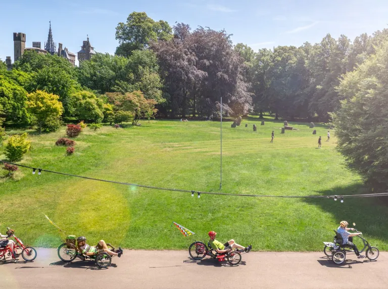 A group of cyclists on a shared path in a green inner city park.