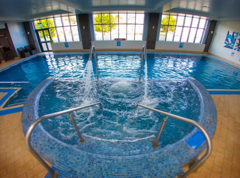 Ein Indoor-Pool mit Wasserfontänen.