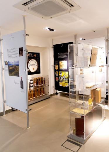 Items displayed in glass cabinets and artwork in the exhibition at Penderyn Distillery.