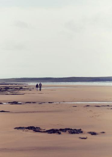 Two people walking on Freshwater West beach, Pembrokeshire