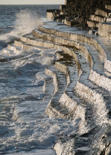 Image of waves crashing on to stone steps on Aberystwyth seafront