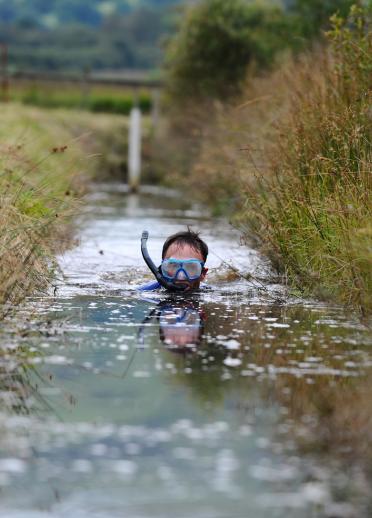 Man in water wearing goggles and a snorkl bog snorkelling.