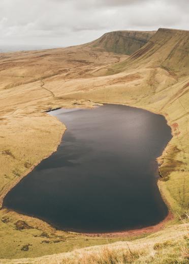 Llyn y Fan Fach from above with cloudy skies.