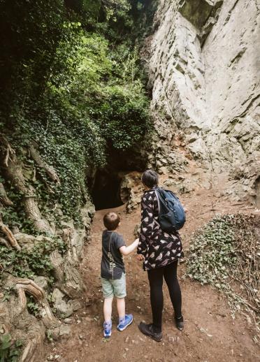 Woman and a small child looking at a cave.