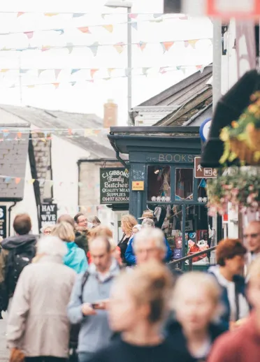 People exploring the steets lined with bunting during the Hay festival at Hay on Wye.
