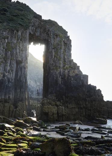 A seaside rock formation with a hole through.