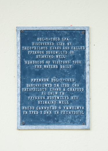 A wall plaque explaining the history of Dol-y-coed spa waters.