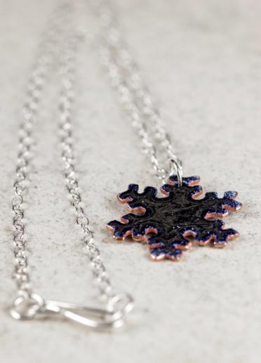 A snowlflake pendant on a silver necklace