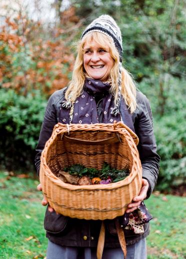 Adele Nozedar with a wicker basket full of foraged plants.