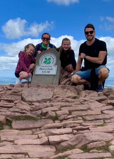 Zwei Erwachsene und zwei Kinder auf dem Gipfel des Pen-y-Fan.