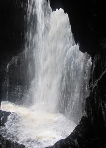 Waterfall cascading through cavern.