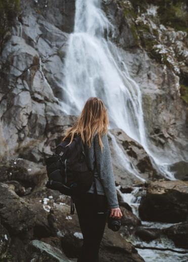 Back of a person looking at waterfall.