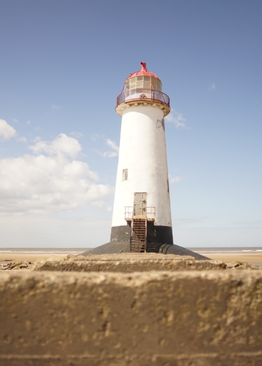 A large lighthouse on a beach.