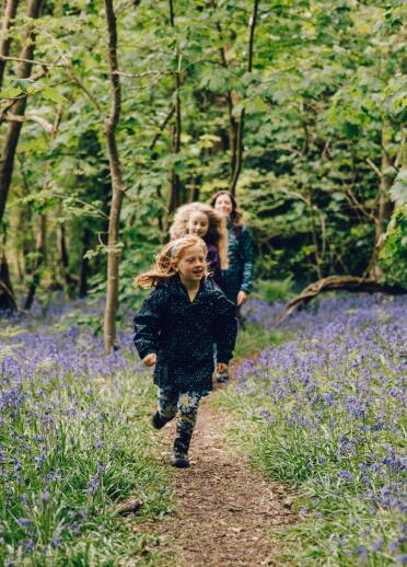 children running through bluebell woods.